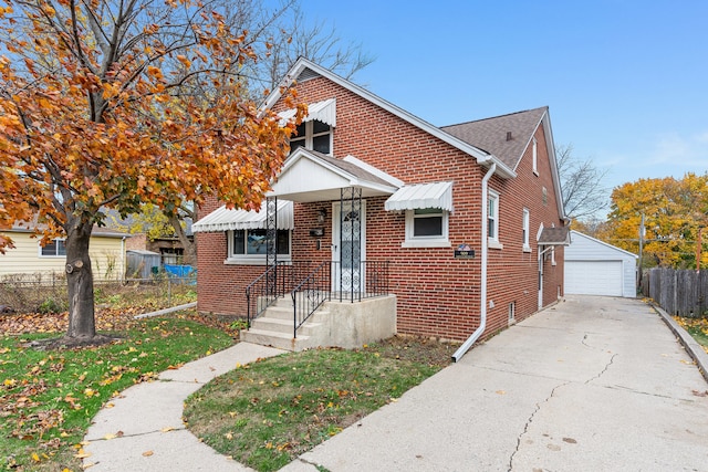 bungalow-style home with a garage, an outbuilding, and a front lawn