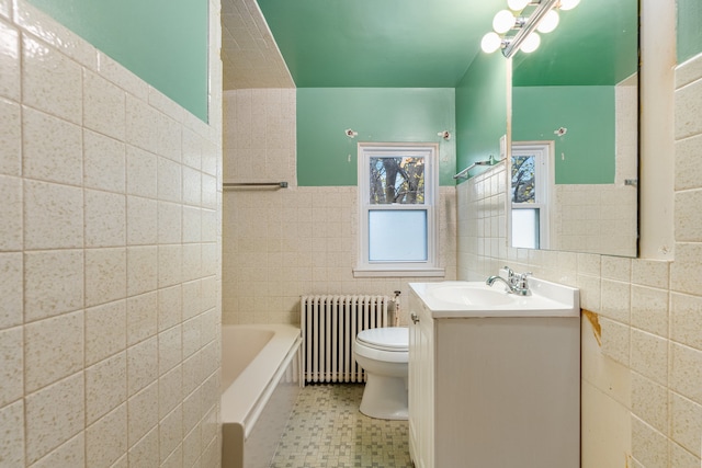 bathroom featuring a bathtub, radiator, vanity, tile walls, and toilet