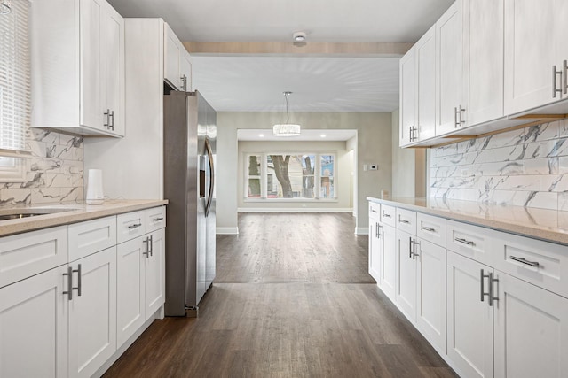 kitchen with dark hardwood / wood-style flooring, light stone countertops, stainless steel fridge with ice dispenser, and white cabinets