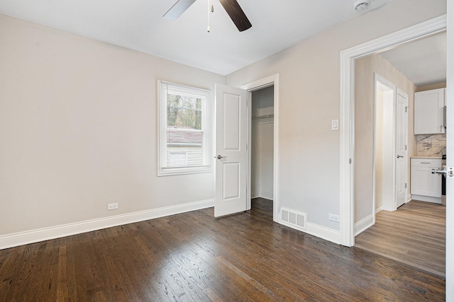 unfurnished bedroom featuring dark wood-type flooring, ceiling fan, and a closet