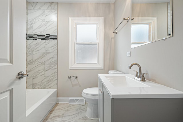 full bathroom with tiled shower / bath, vanity, and toilet