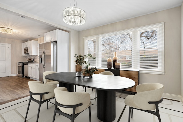 dining space with an inviting chandelier and light hardwood / wood-style flooring