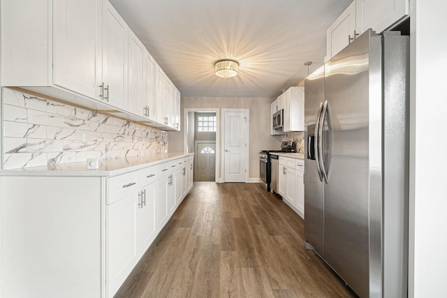 kitchen with white cabinetry, dark hardwood / wood-style floors, pendant lighting, stainless steel appliances, and backsplash