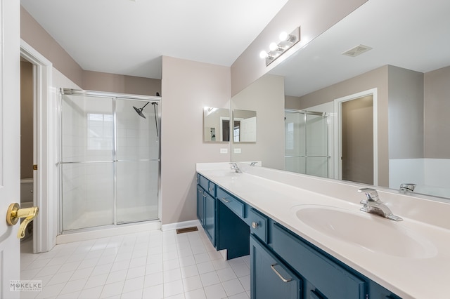 bathroom with tile patterned flooring, vanity, and walk in shower