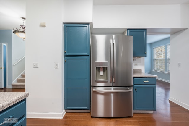 kitchen with stainless steel fridge, hardwood / wood-style flooring, and blue cabinets