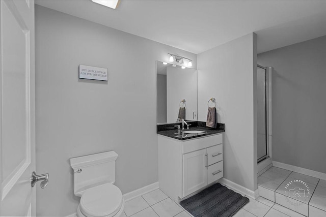 bathroom with tile patterned floors, a shower with door, vanity, and toilet