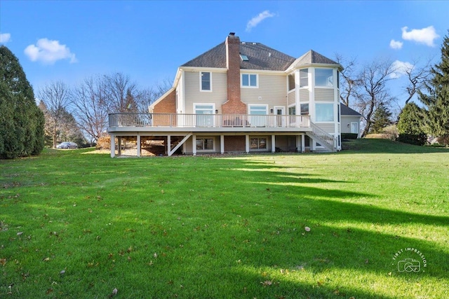 rear view of property featuring a lawn and a wooden deck