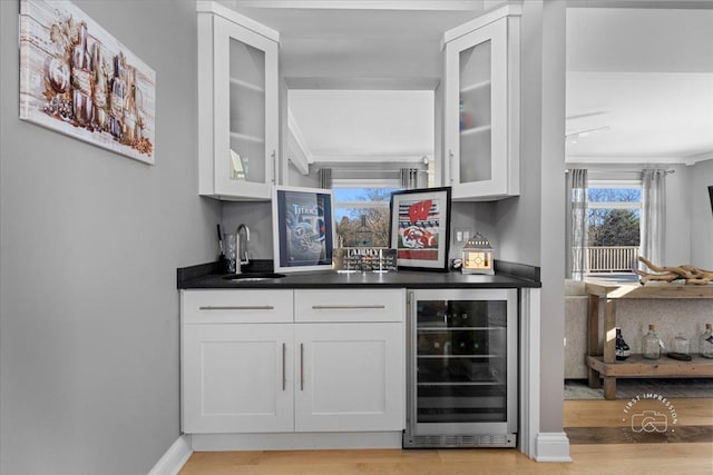 bar featuring white cabinetry, sink, wine cooler, and light hardwood / wood-style flooring