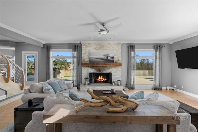 living room with a stone fireplace, plenty of natural light, and crown molding