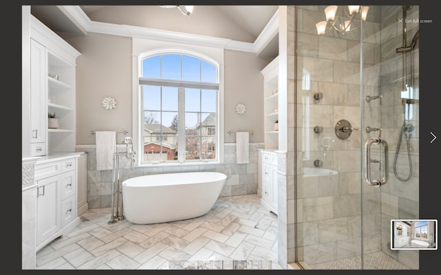 bathroom featuring vanity, lofted ceiling, tile walls, and plus walk in shower