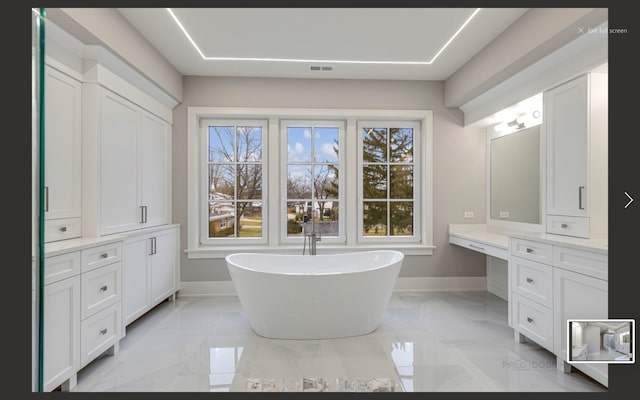 bathroom with vanity and a tub