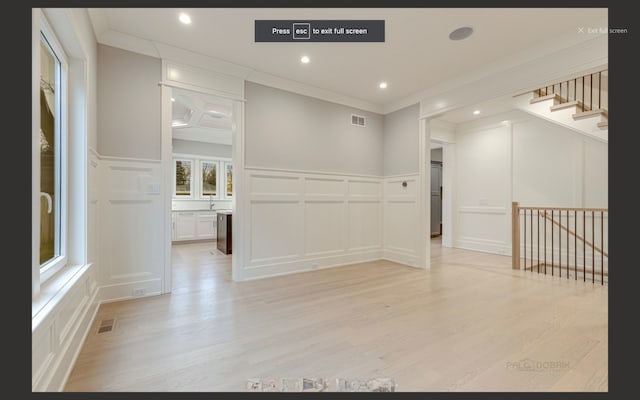 spare room with crown molding and light hardwood / wood-style flooring