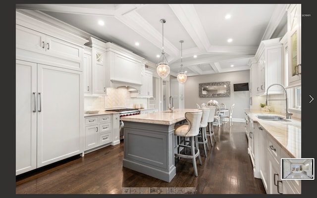 kitchen with sink, white cabinetry, and an island with sink