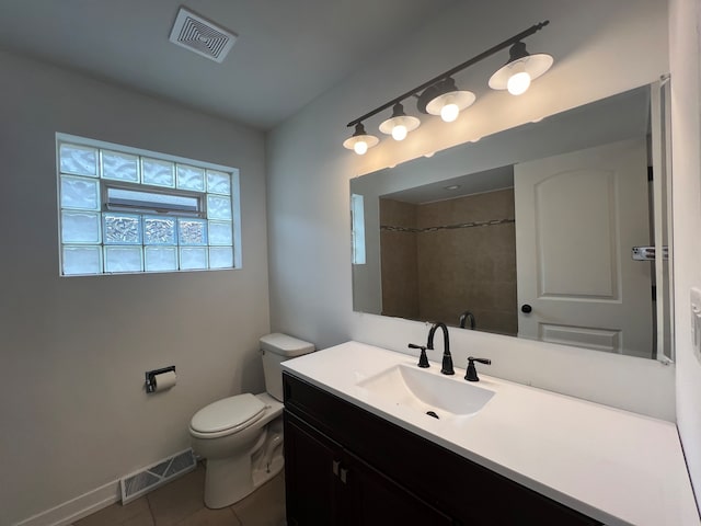 bathroom with tiled shower, tile patterned floors, vanity, and toilet