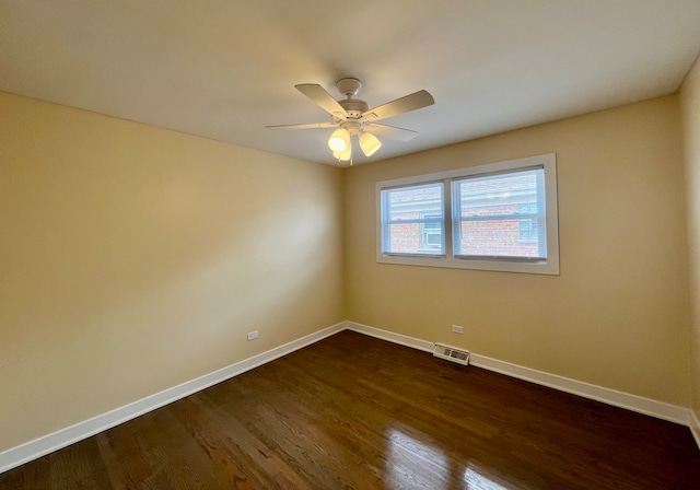 spare room with dark hardwood / wood-style flooring and ceiling fan