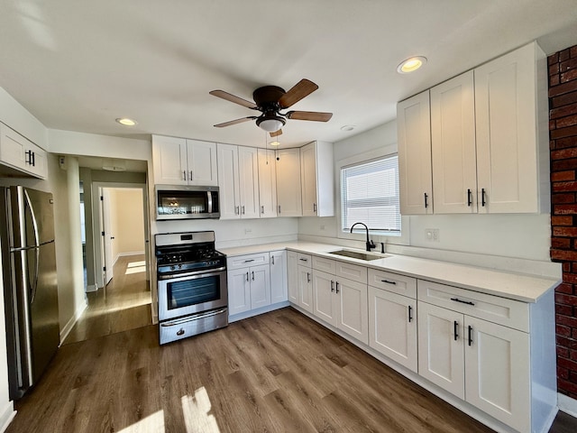 kitchen featuring hardwood / wood-style flooring, white cabinetry, sink, and appliances with stainless steel finishes