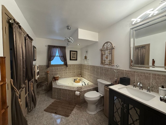 bathroom featuring vanity, tile walls, tile patterned flooring, tiled bath, and toilet