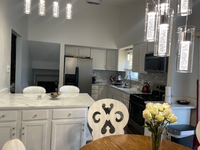 kitchen featuring white cabinets, sink, light stone countertops, tasteful backsplash, and stainless steel appliances