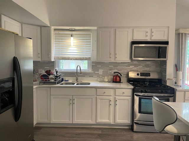 kitchen featuring sink, decorative backsplash, appliances with stainless steel finishes, light stone counters, and white cabinetry