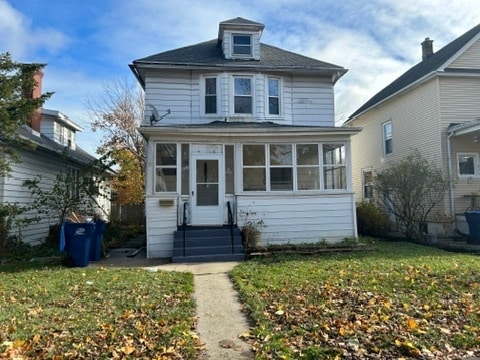 view of front property with a sunroom and a front lawn