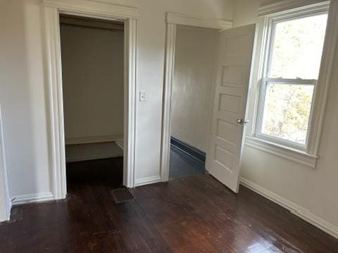 833 Hickory St, Waukegan, IL 60085 - unfurnished bedroom with dark wood finished floors, multiple windows, and a closet