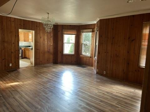 833 Hickory St, Waukegan, IL 60085 - unfurnished dining area featuring a chandelier, wood finished floors, ornamental molding, and wooden walls