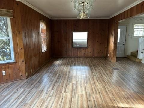 833 Hickory St, Waukegan, IL 60085 - empty room featuring stairs, wood finished floors, wood walls, and crown molding