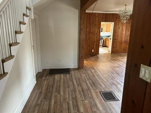 833 Hickory St, Waukegan, IL 60085 - hall featuring a chandelier, wood finished floors, stairway, and wooden walls