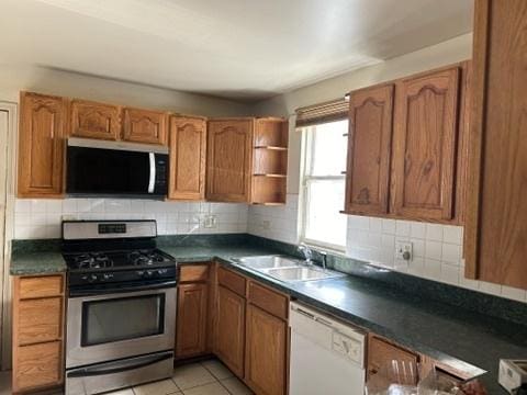 833 Hickory St, Waukegan, IL 60085 - kitchen with stainless steel gas range oven, dishwasher, dark countertops, and brown cabinets