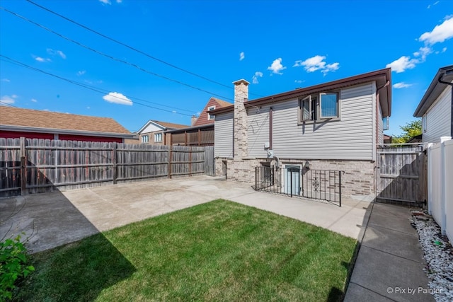 back of house with a patio area and a lawn