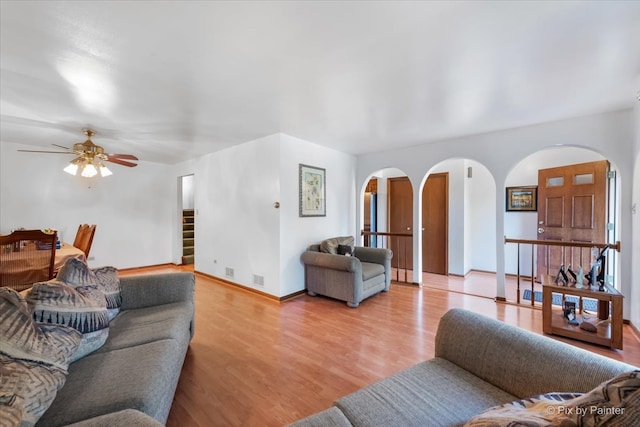 living room with ceiling fan and light hardwood / wood-style flooring