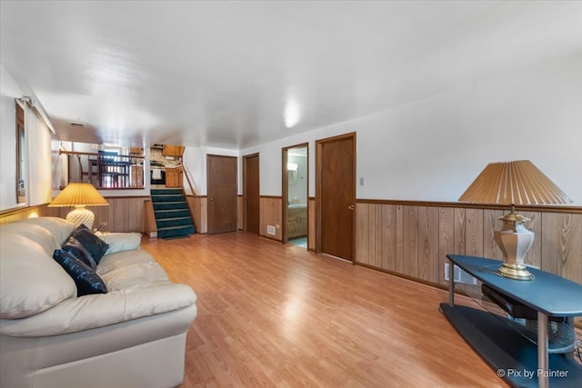 living room with light wood-type flooring and wood walls