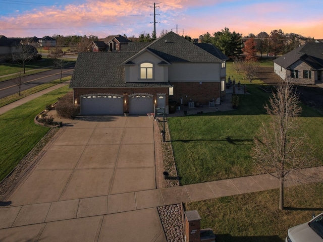 view of property with a garage and a lawn