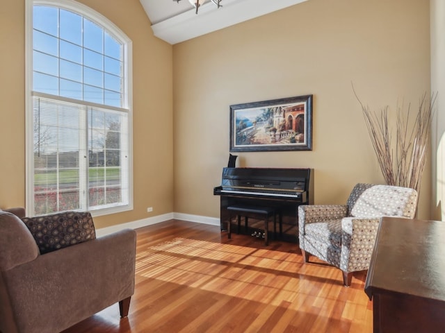 living area featuring plenty of natural light, wood-type flooring, and vaulted ceiling