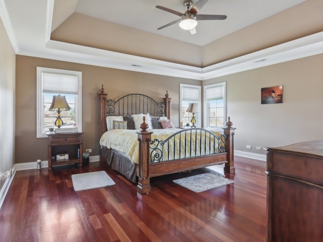 bedroom featuring ceiling fan, dark hardwood / wood-style flooring, ornamental molding, and multiple windows