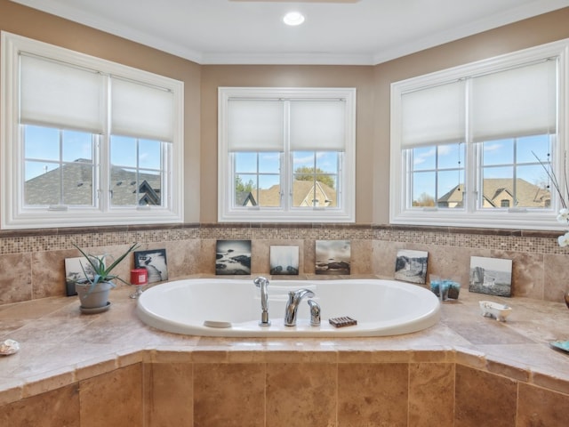 bathroom with tiled tub, crown molding, and a wealth of natural light