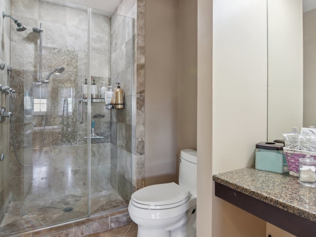 bathroom featuring tile patterned floors, toilet, vanity, and walk in shower