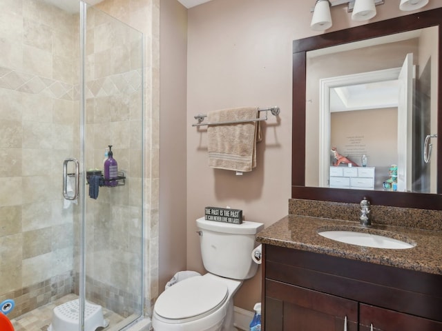 bathroom featuring vanity, toilet, and walk in shower