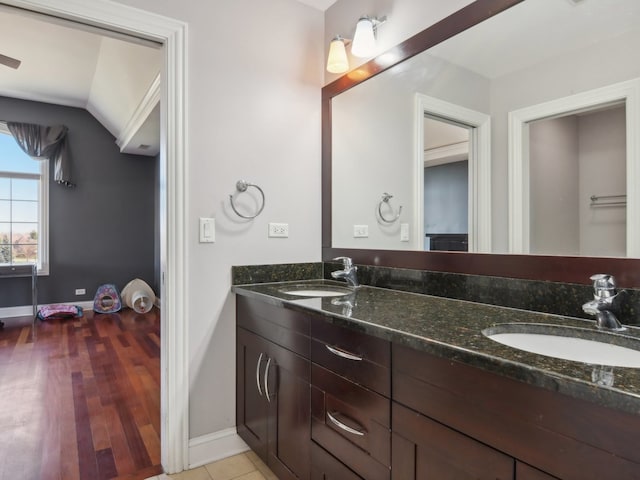 bathroom with hardwood / wood-style floors, vanity, and lofted ceiling