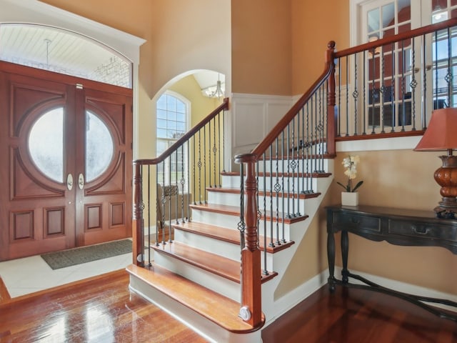 foyer entrance with hardwood / wood-style floors and a notable chandelier