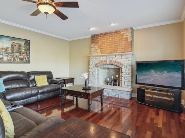 living room featuring a brick fireplace, crown molding, ceiling fan, and dark wood-type flooring