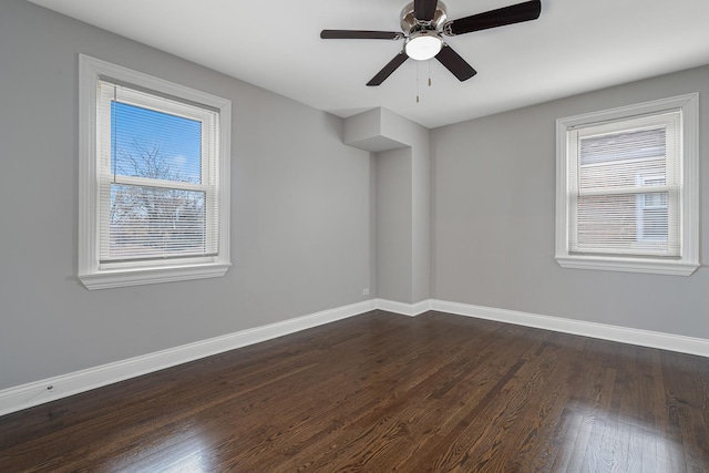 unfurnished room featuring a wealth of natural light, ceiling fan, and dark wood-type flooring