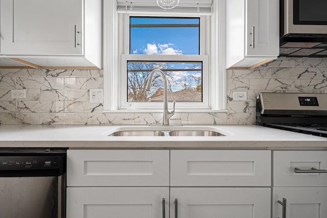 kitchen featuring backsplash, stainless steel appliances, white cabinetry, and sink