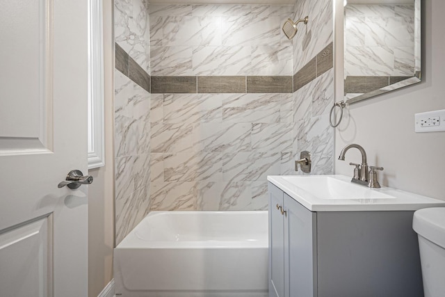 full bathroom featuring tiled shower / bath combo, toilet, and vanity