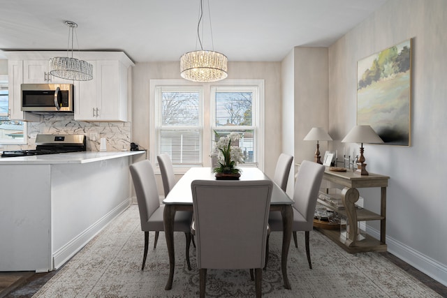 dining area featuring wood-type flooring and an inviting chandelier