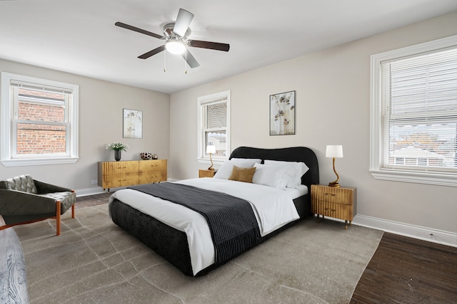 bedroom featuring hardwood / wood-style flooring, ceiling fan, and multiple windows