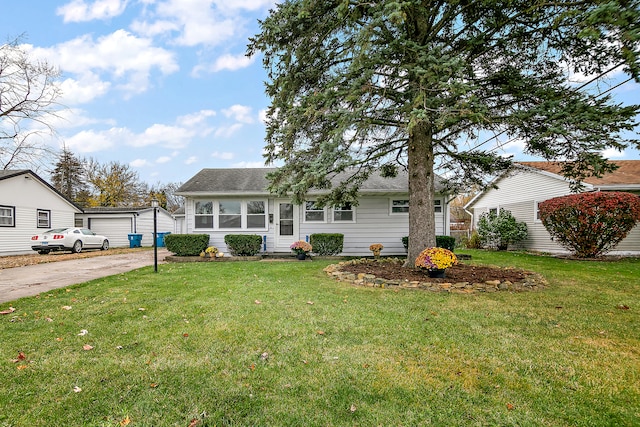 view of front of property featuring an outbuilding, a front lawn, and a garage