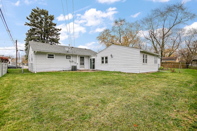 rear view of property with a lawn and cooling unit