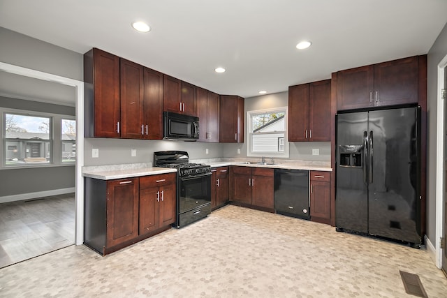 kitchen featuring sink, light wood-type flooring, and black appliances