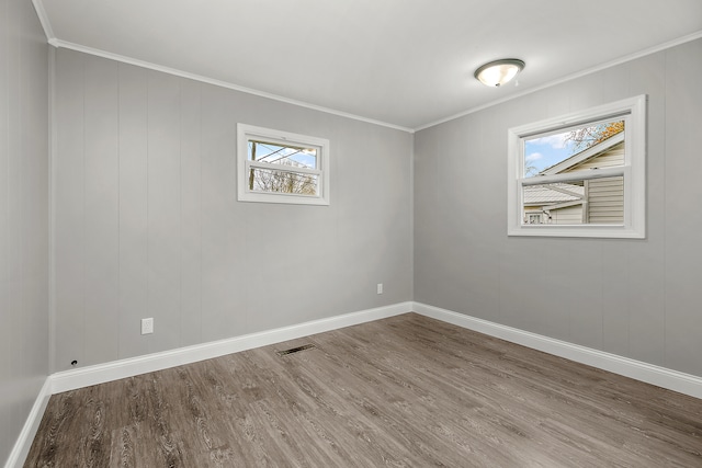 empty room featuring ornamental molding and hardwood / wood-style flooring